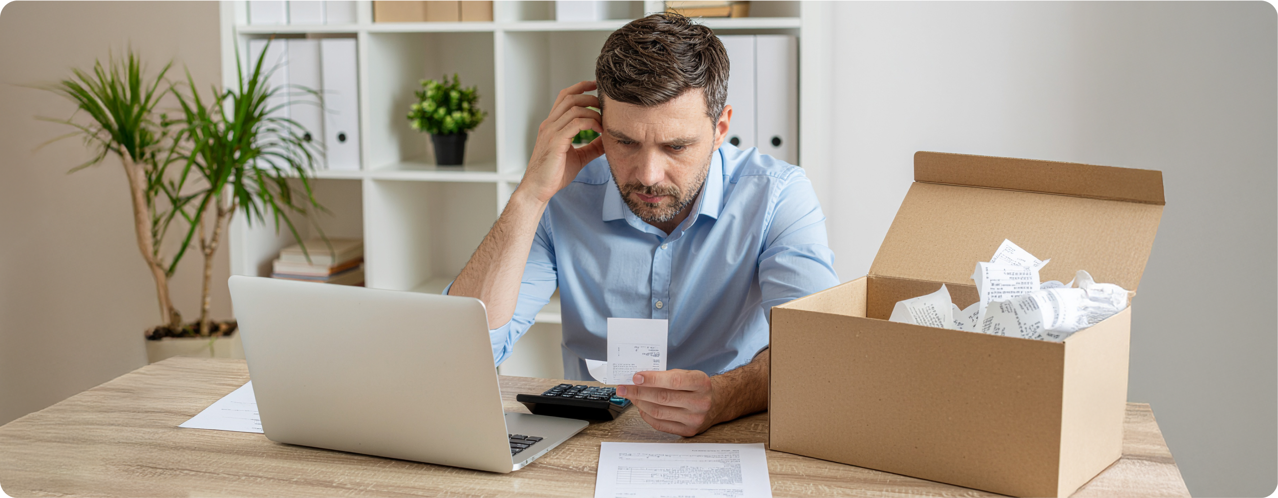 Frustrated accountant dealing with paper receipts to track expenses